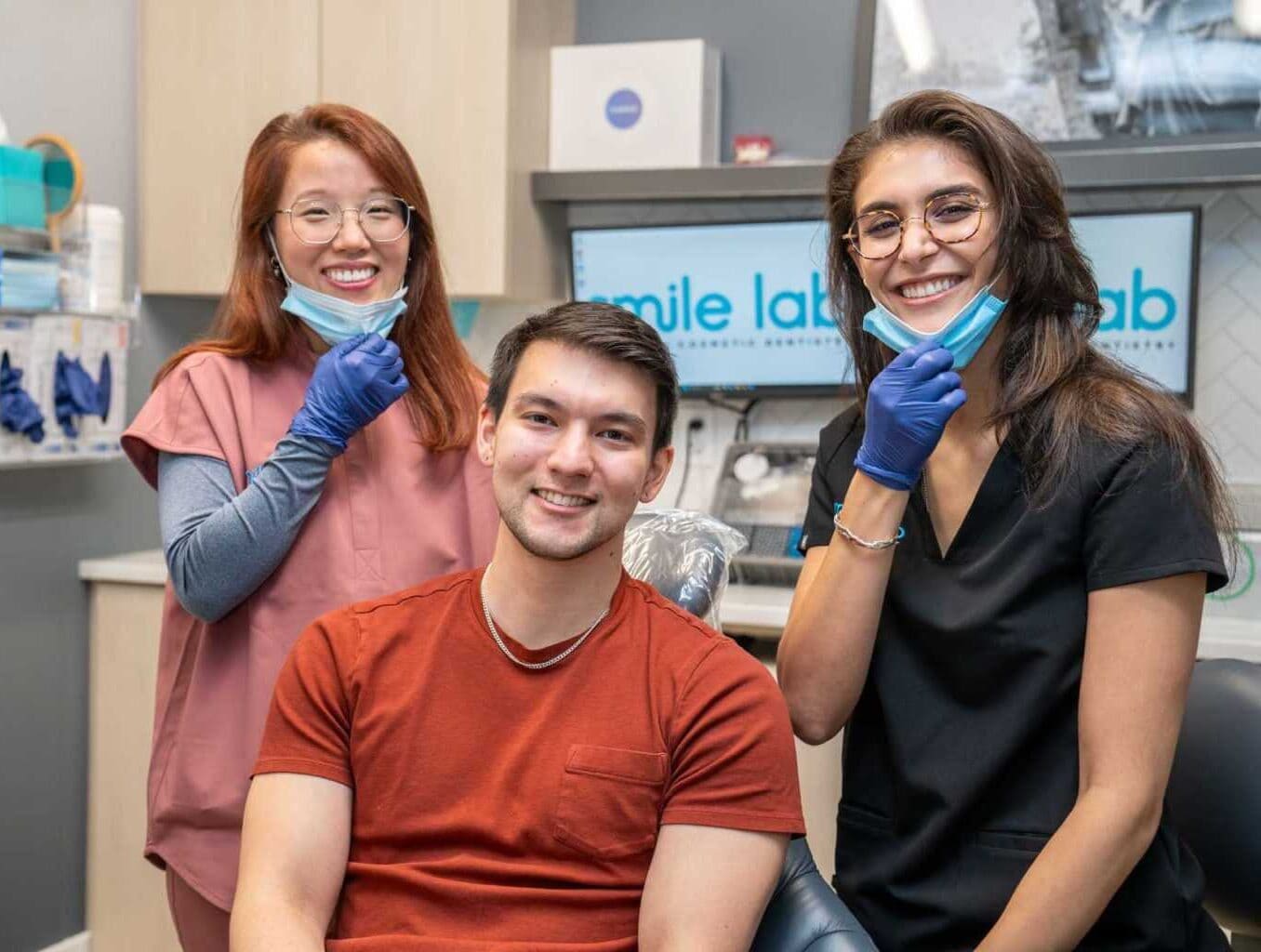 Two team members smiling with a patient