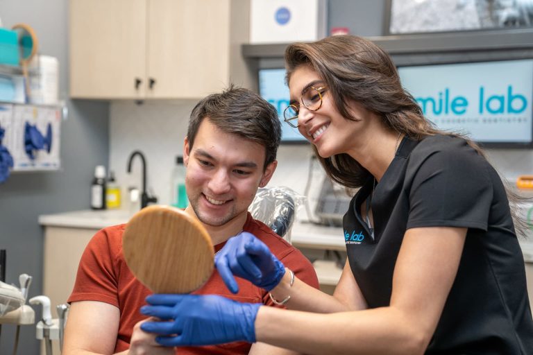 A team member showing a patient his smile